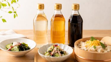 色の違う酢が3本並び、手前に酢の物の小鉢と寿司飯を入れた飯台が置かれている