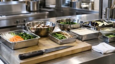 和食の厨房の調理台。下ごしらえを終えた野菜や豆腐がバットやボウルに並んでいる